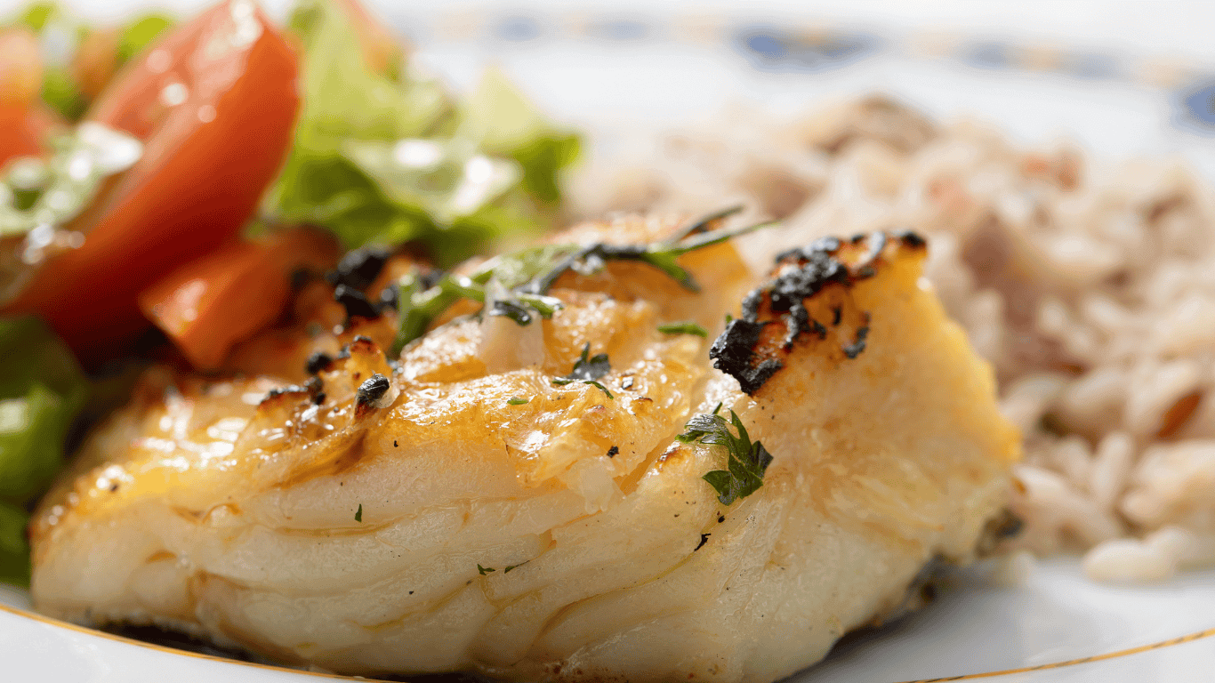 El "bacalao assado na brasa" es una receta portuguesa que consiste en cocinar lomos de bacalao a la parrilla, a menudo con un toque de ajo y aceite de oliva. El bacalao desalado se asa directamente sobre las brasas, resultando en un exterior crujiente y un interior jugoso. Se suele acompañar de patatas, cebolla y aceitunas negras.