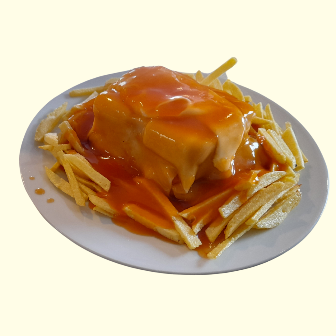 **Francesinha**   Sándwich relleno de carnes, cubierto con queso fundido y bañado en una salsa especial a base de tomate y cerveza. Servido con huevo frito y patatas fritas. ¡Una delicia contundente!